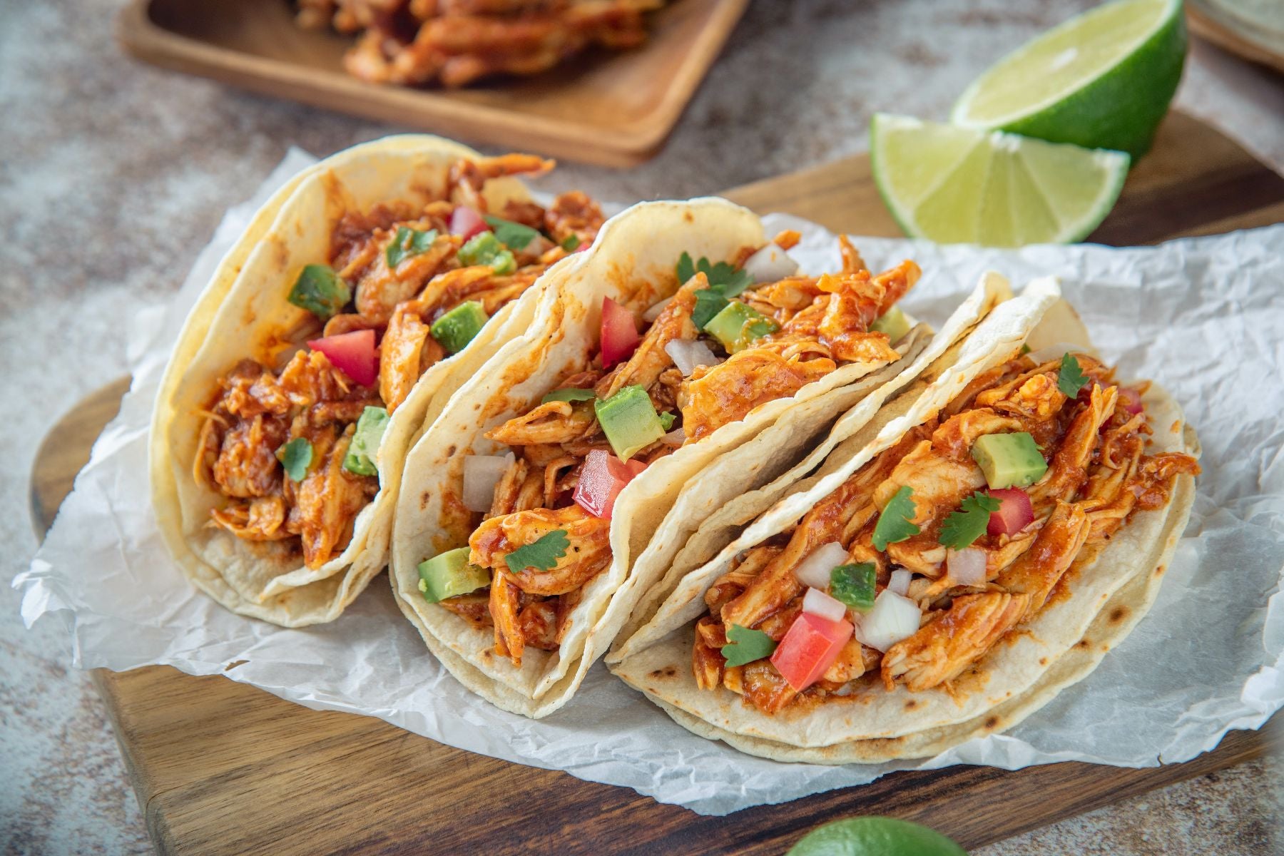 bbq pulled chicken tacos with lime wedges